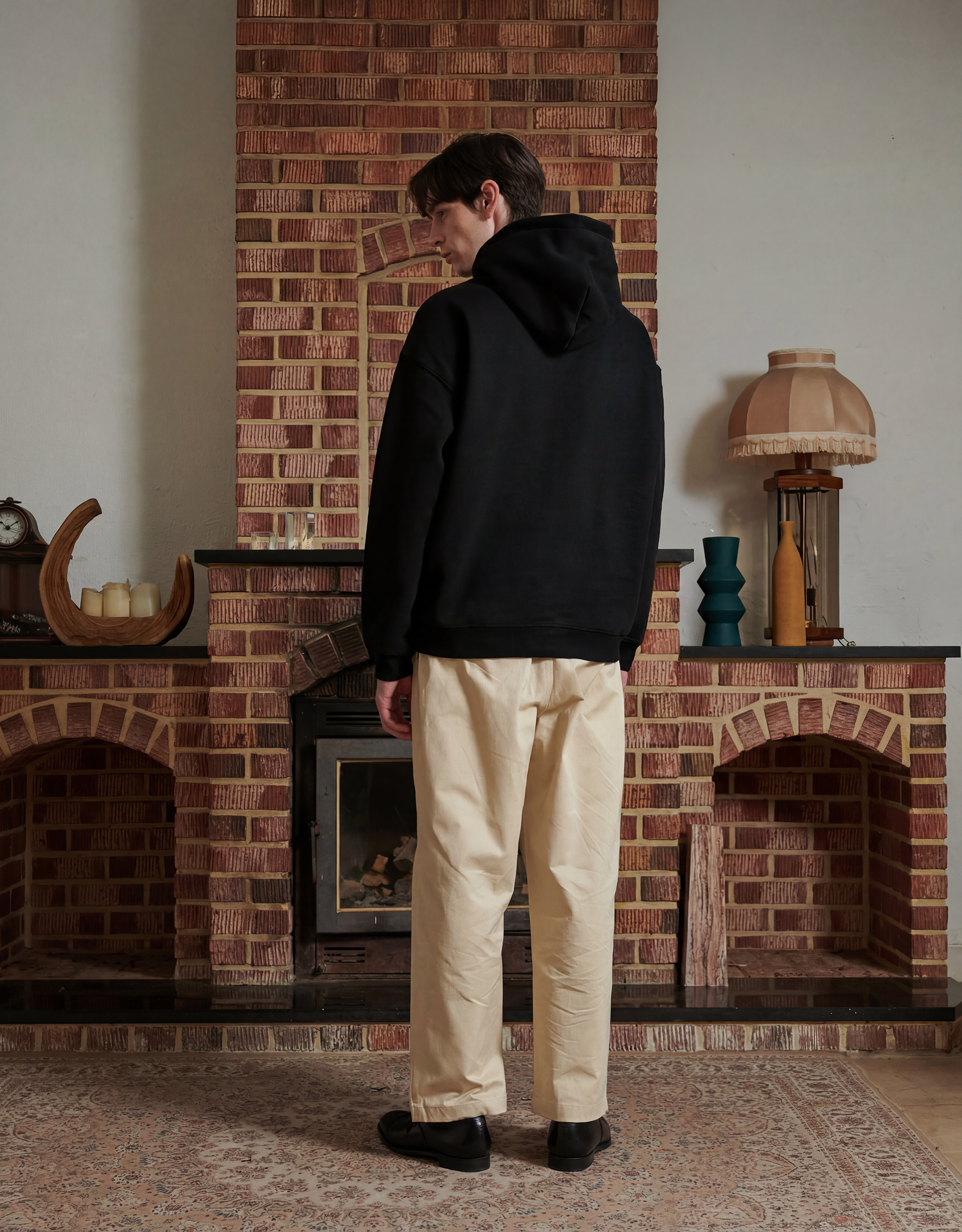Male model wearing black hoodie facing backward