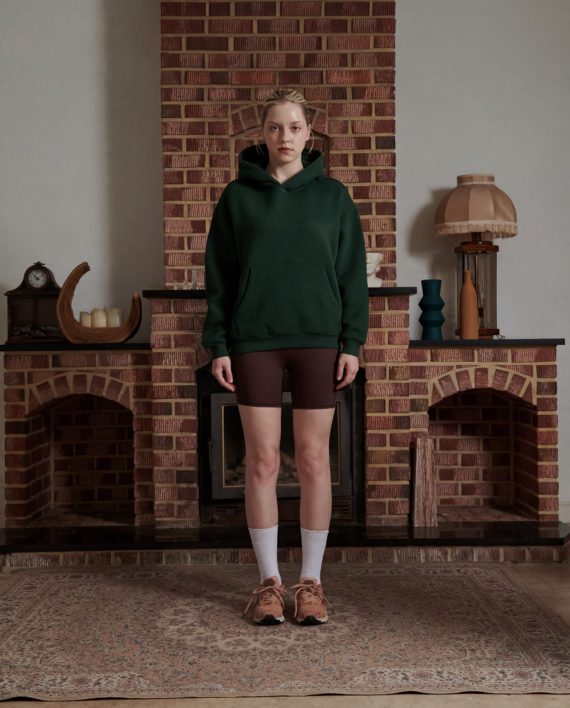female model wearing a forest green hoodie facing forward